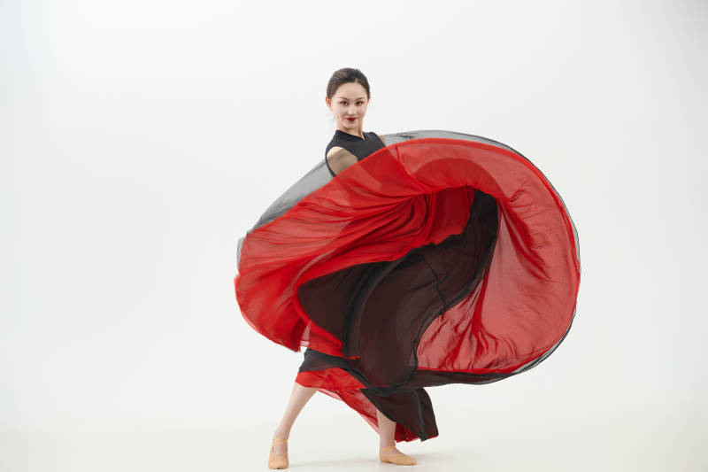 身穿红黑相间的舞蹈长裙翩翩起舞的少女图片