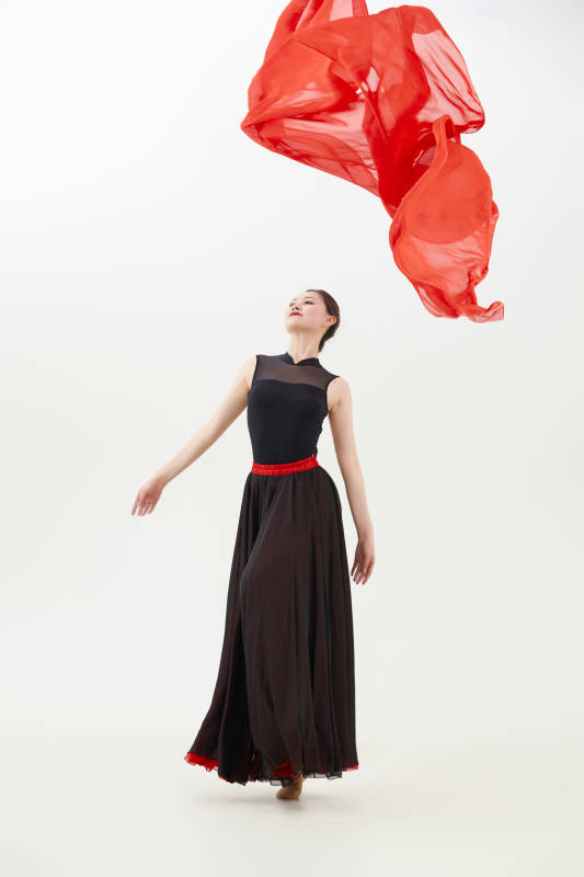 身穿红黑相间的舞蹈长裙翩翩起舞的少女图片