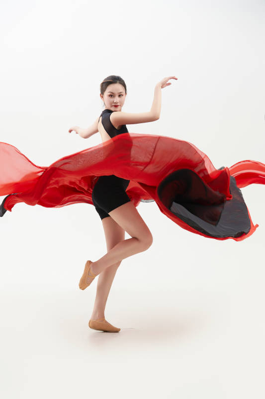 身穿红黑相间的舞蹈长裙翩翩起舞的少女图片