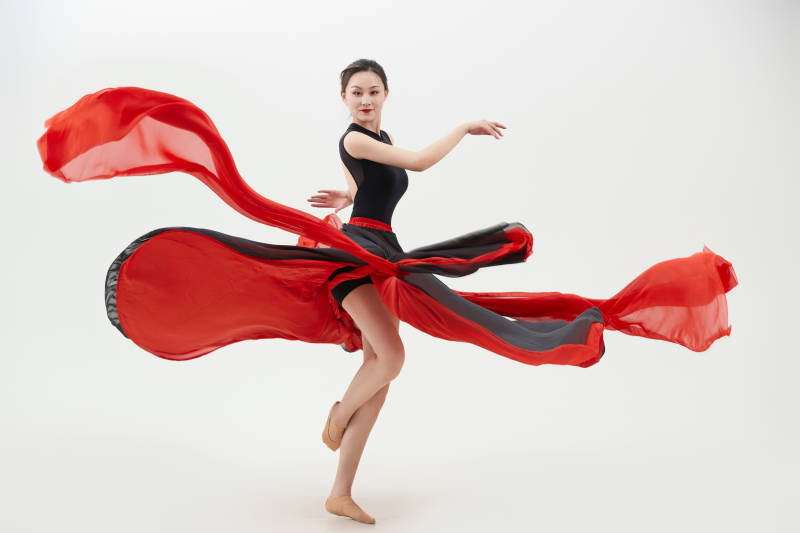 身穿红黑相间的舞蹈长裙翩翩起舞的少女图片