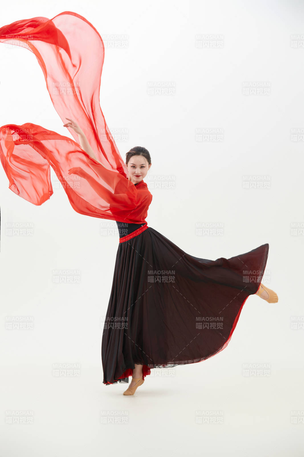 身穿红黑相间的舞蹈长裙翩翩起舞的少女图片