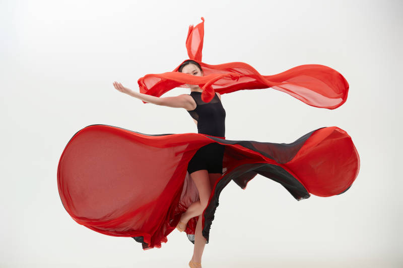 身穿红黑相间的舞蹈长裙翩翩起舞的少女图片