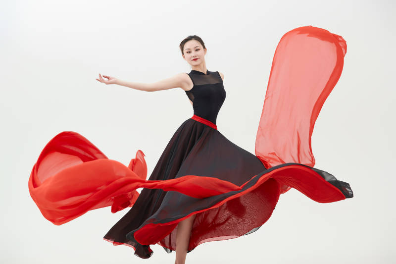 身穿红黑相间的舞蹈长裙翩翩起舞的少女图片