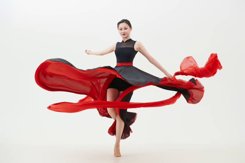 身穿红黑相间的舞蹈长裙翩翩起舞的少女图片