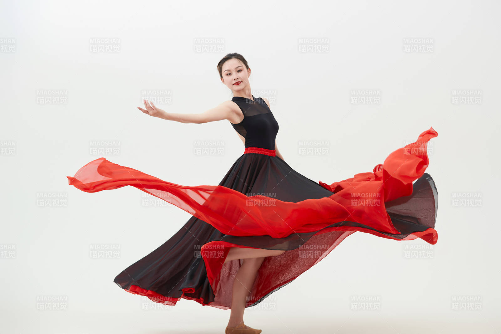 身穿红黑相间的舞蹈长裙翩翩起舞的少女图片
