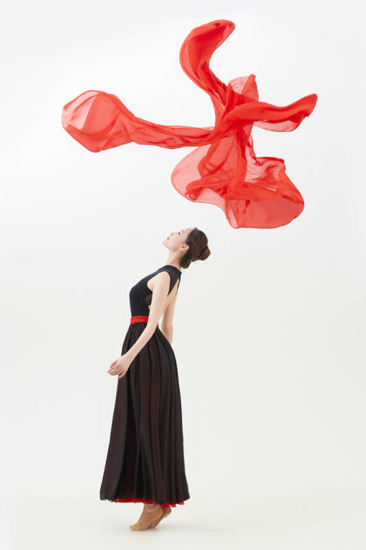 身穿红黑相间的舞蹈长裙翩翩起舞的少女图片