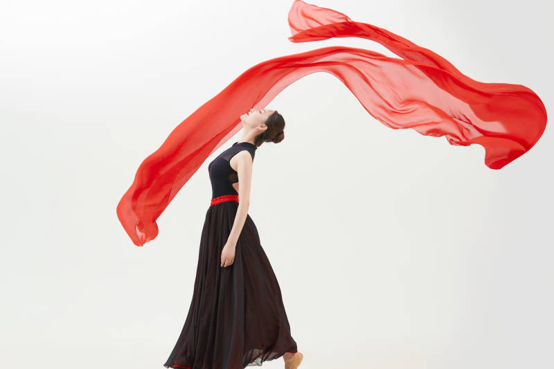 身穿红黑相间的舞蹈长裙翩翩起舞的少女图片