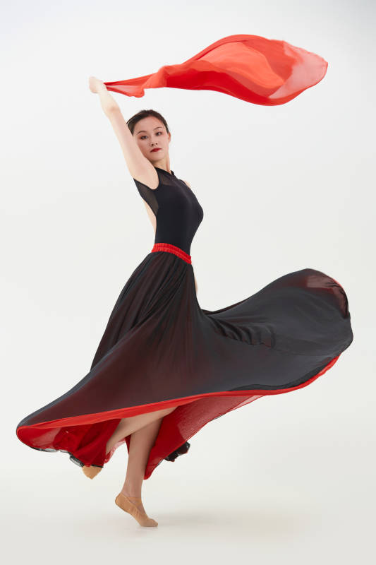 身穿红黑相间的舞蹈长裙翩翩起舞的少女图片