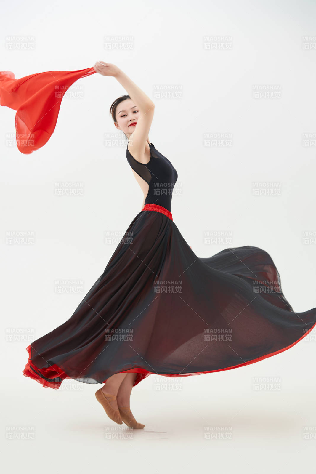 身穿红黑相间的舞蹈长裙翩翩起舞的少女图片