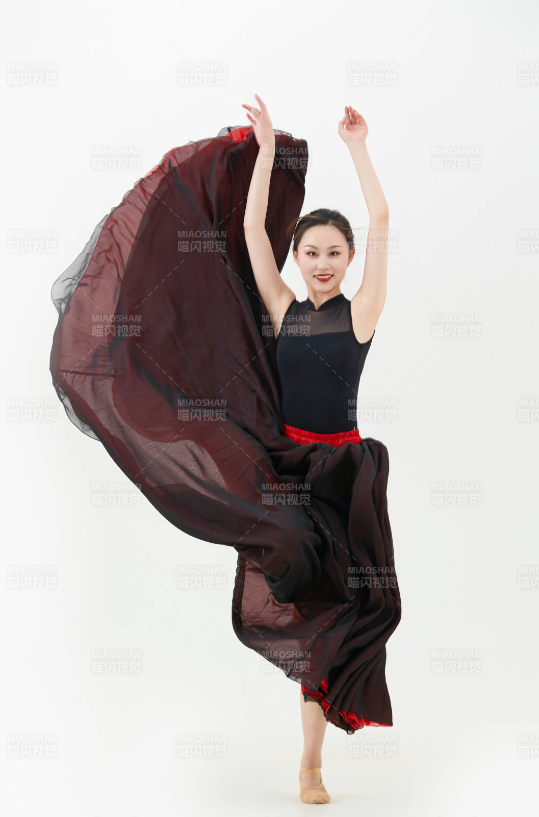 身穿红黑相间的舞蹈长裙翩翩起舞的少女图片