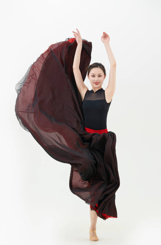 身穿红黑相间的舞蹈长裙翩翩起舞的少女图片