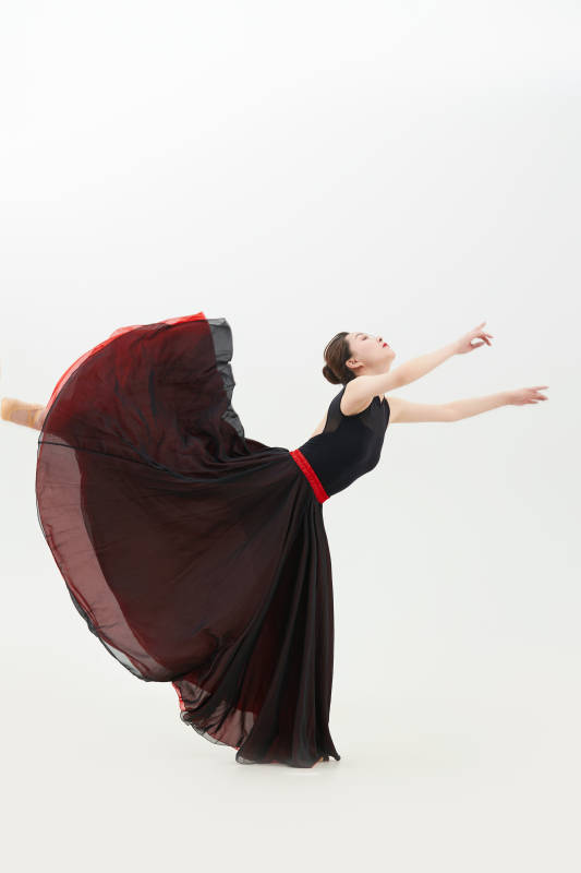 身穿红黑相间的舞蹈长裙翩翩起舞的少女图片