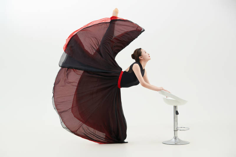 身穿红黑相间的舞蹈长裙翩翩起舞的少女图片