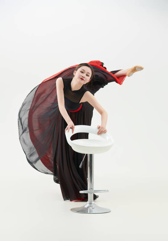 身穿红黑相间的舞蹈长裙翩翩起舞的少女图片