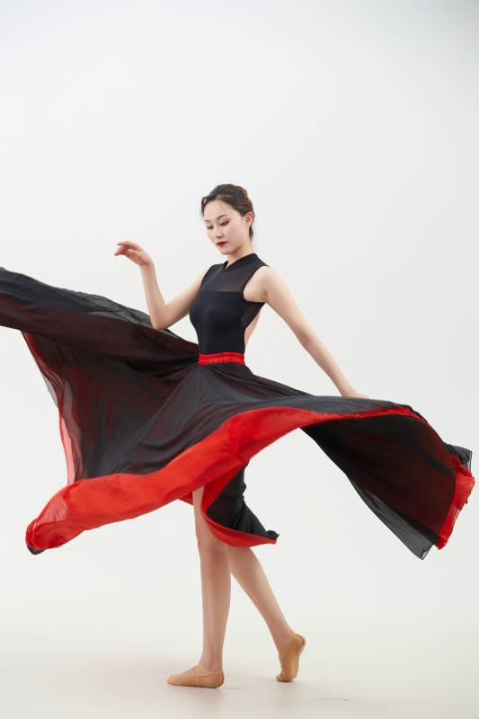 身穿红黑相间的舞蹈长裙翩翩起舞的少女图片