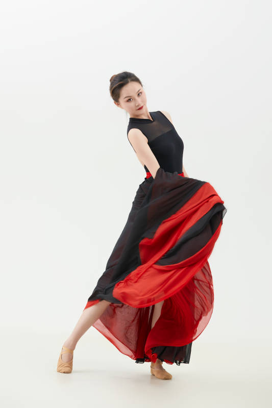 身穿红黑相间的舞蹈长裙翩翩起舞的少女图片