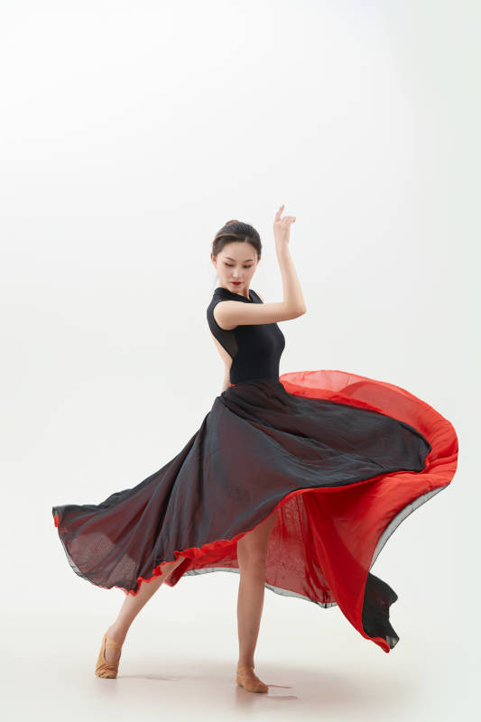 身穿红黑相间的舞蹈长裙翩翩起舞的少女图片