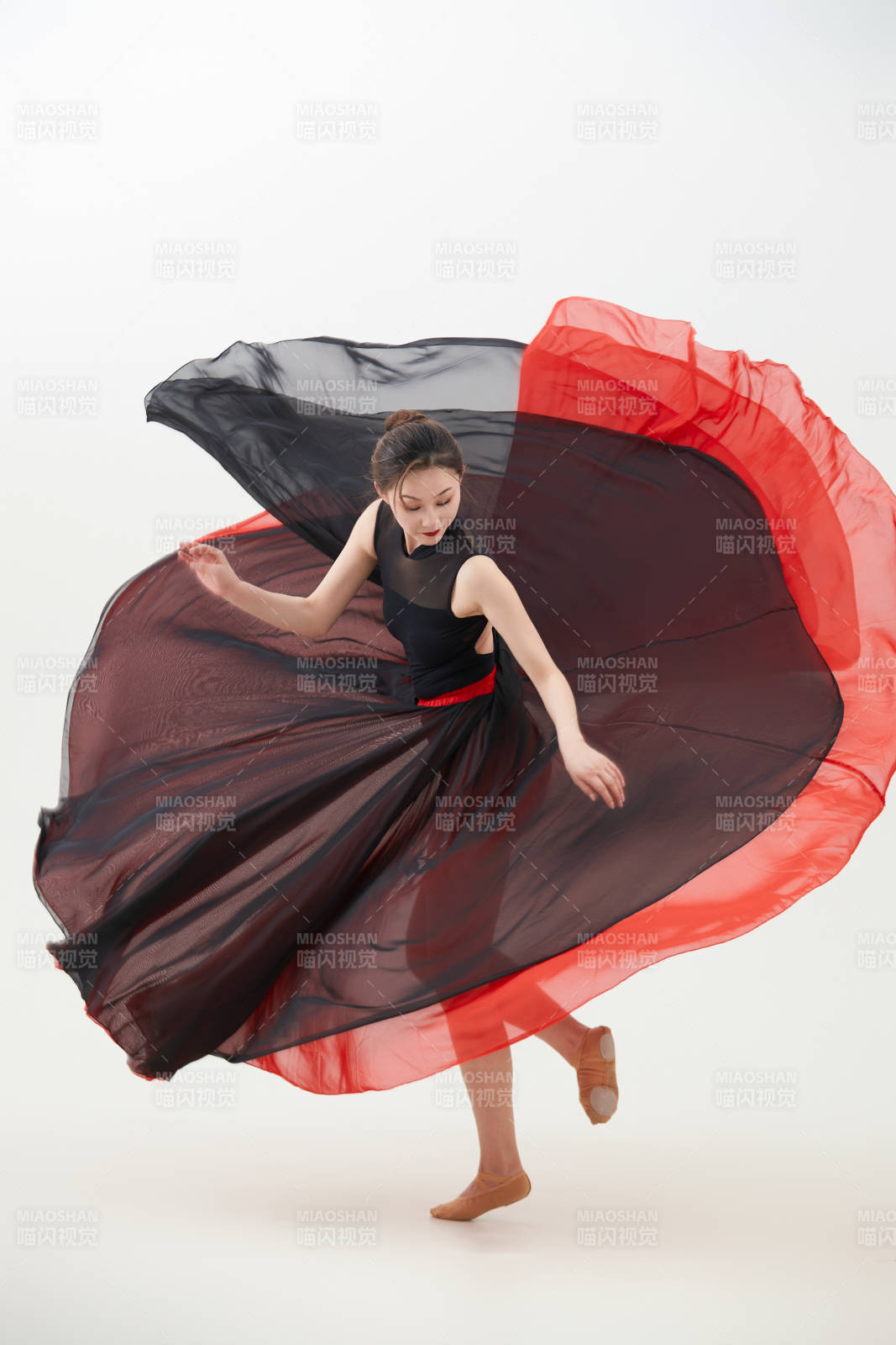 身穿红黑相间的舞蹈长裙翩翩起舞的少女图片