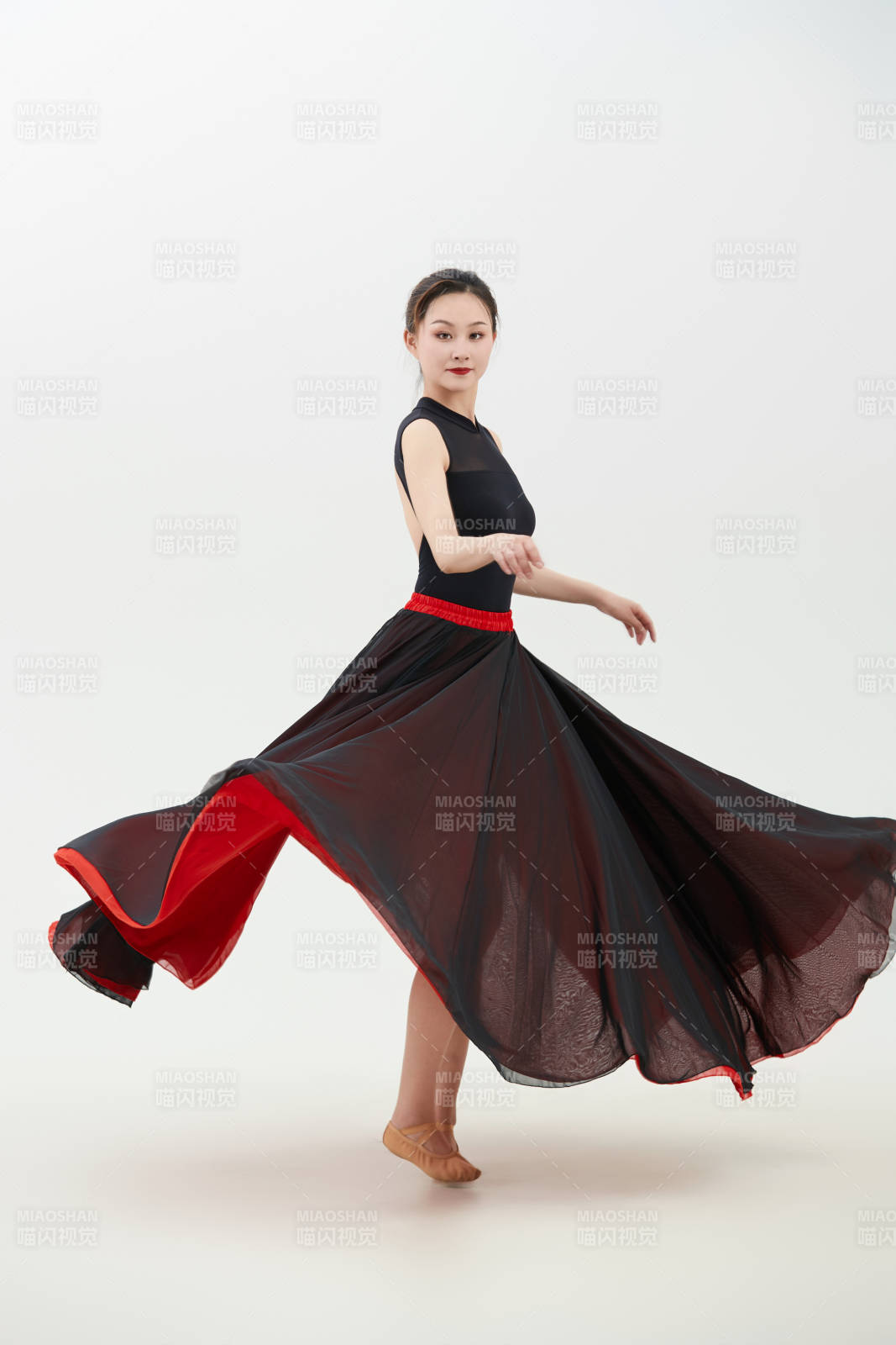 身穿红黑相间的舞蹈长裙翩翩起舞的少女图片