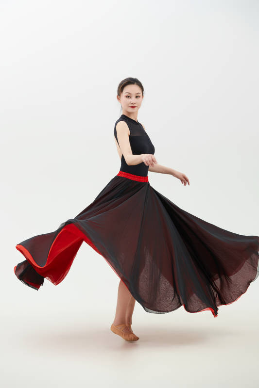 身穿红黑相间的舞蹈长裙翩翩起舞的少女图片