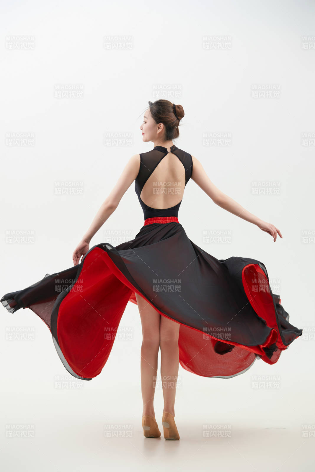 身穿红黑相间的舞蹈长裙翩翩起舞的少女图片