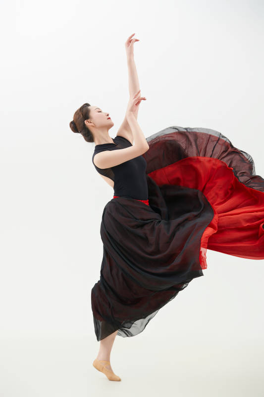 身穿红黑相间的舞蹈长裙翩翩起舞的少女图片