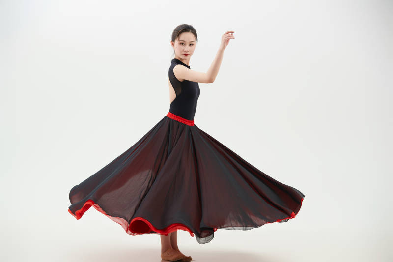 身穿红黑相间的舞蹈长裙翩翩起舞的少女图片