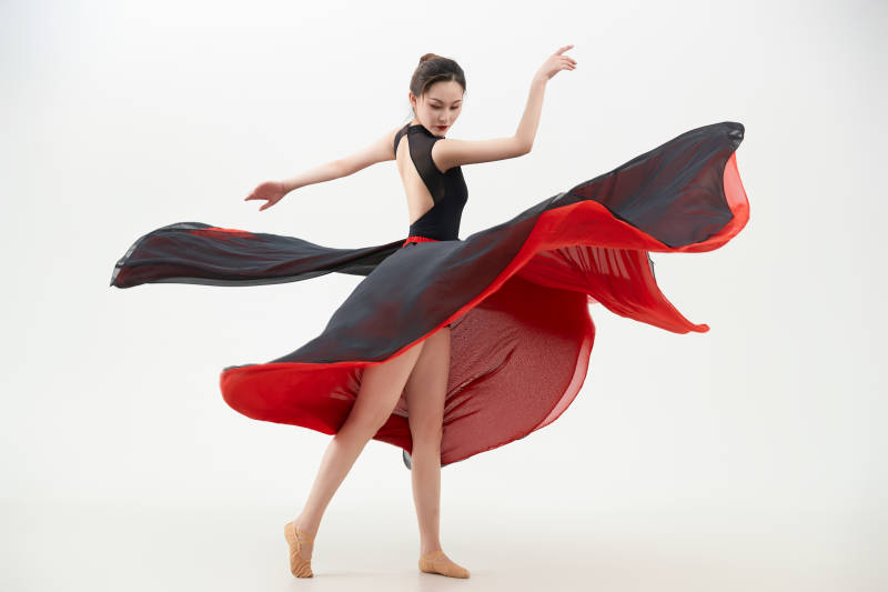 身穿红黑相间的舞蹈长裙翩翩起舞的少女图片