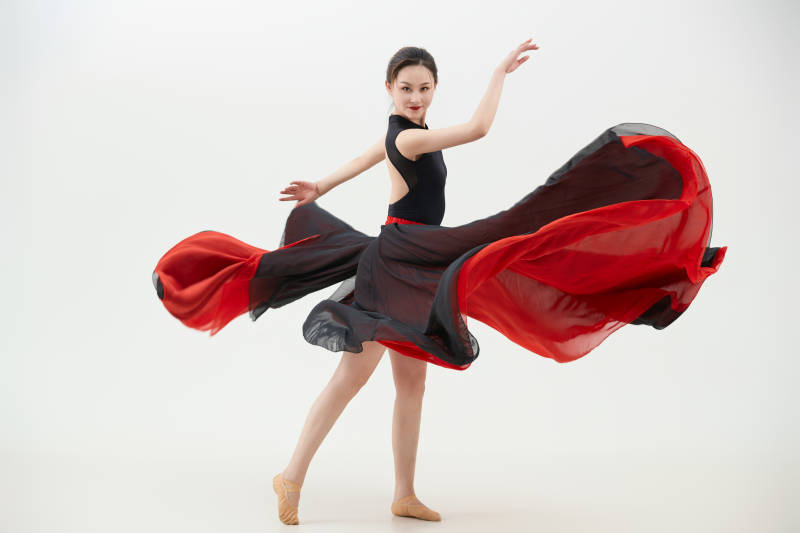 身穿红黑相间的舞蹈长裙翩翩起舞的少女图片