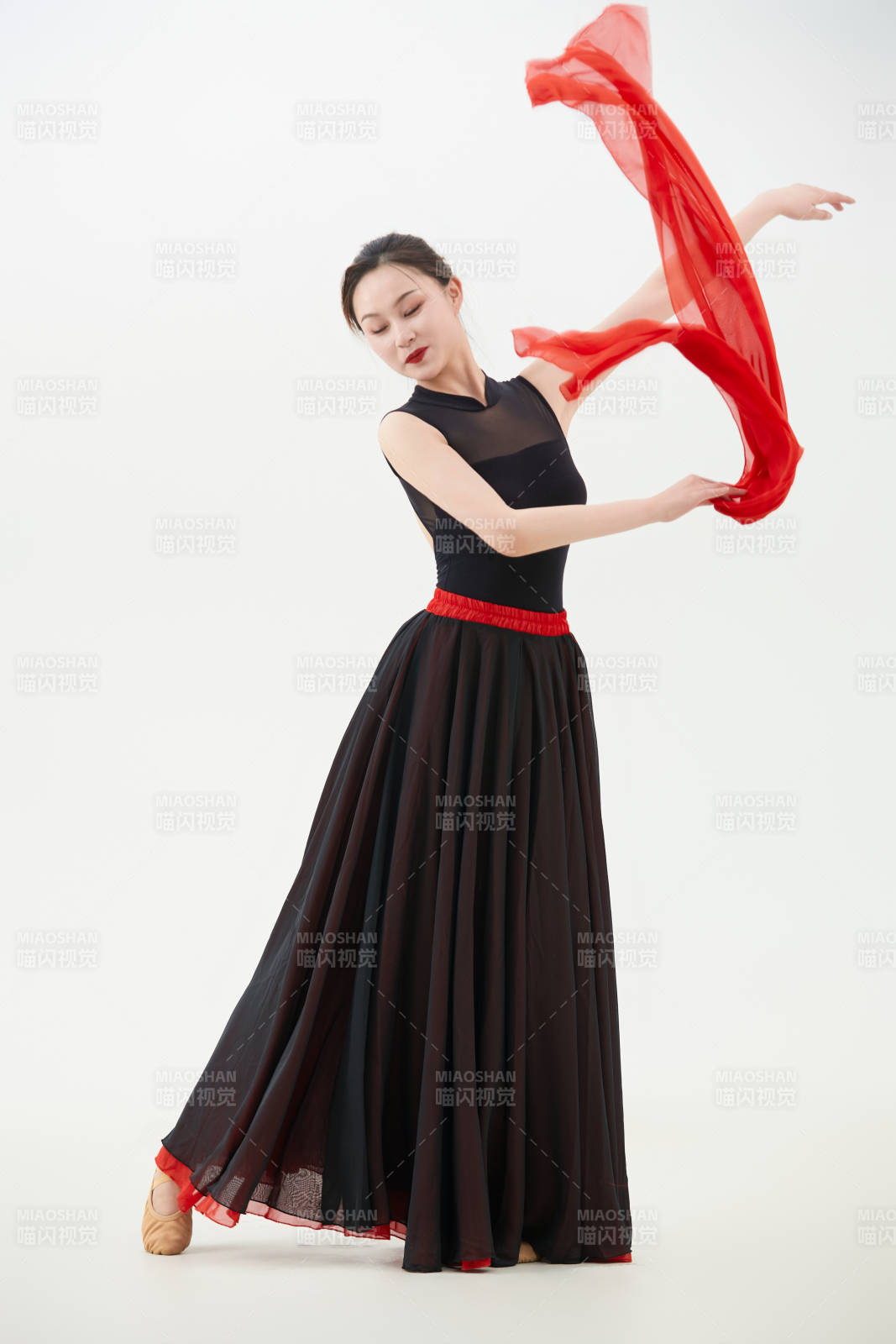 身穿红黑相间的舞蹈长裙翩翩起舞的少女图片