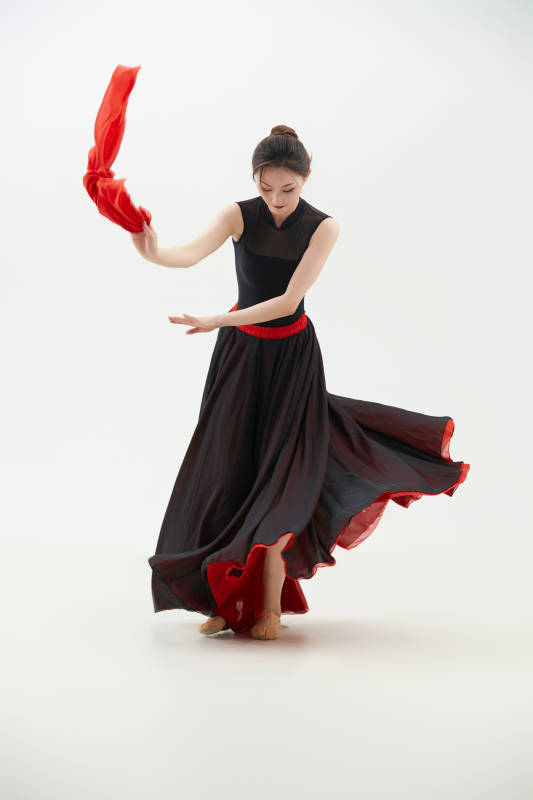 身穿红黑相间的舞蹈长裙翩翩起舞的少女图片