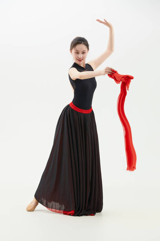 身穿红黑相间的舞蹈长裙翩翩起舞的少女图片