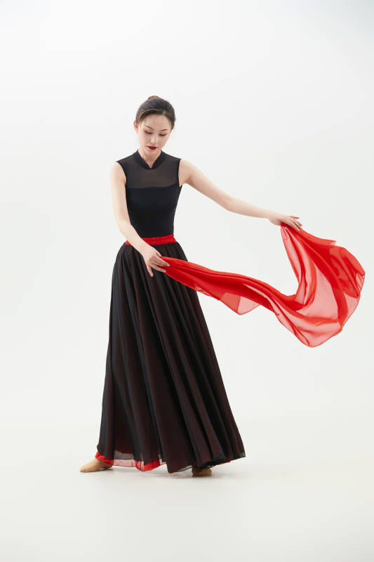 身穿红黑相间的舞蹈长裙翩翩起舞的少女图片
