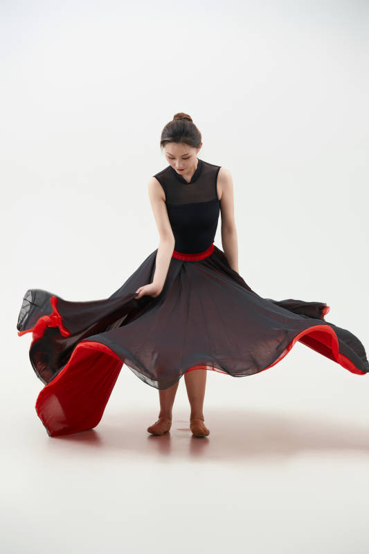身穿红黑相间的舞蹈长裙翩翩起舞的少女图片
