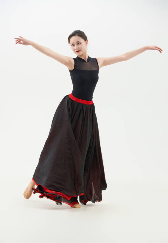 身穿红黑相间的舞蹈长裙翩翩起舞的少女图片