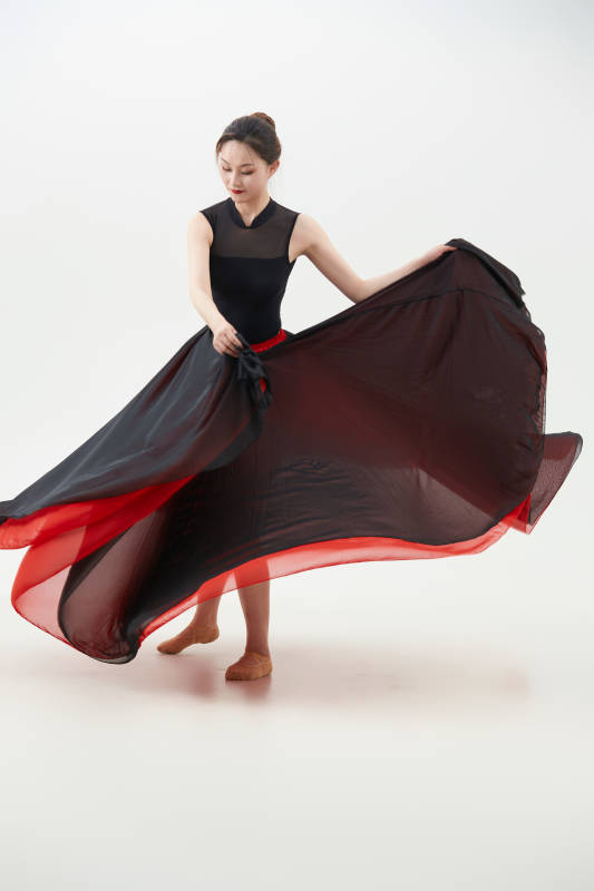 身穿红黑相间的舞蹈长裙翩翩起舞的少女图片