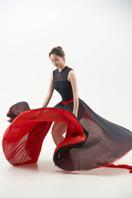 身穿红黑相间的舞蹈长裙翩翩起舞的少女图片