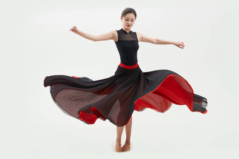 身穿红黑相间的舞蹈长裙翩翩起舞的少女图片