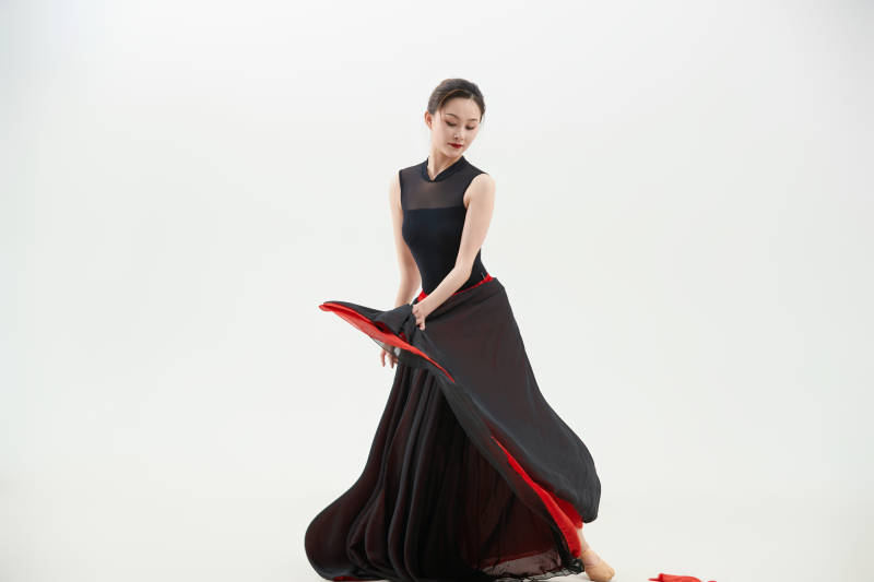 身穿红黑相间的舞蹈长裙翩翩起舞的少女图片