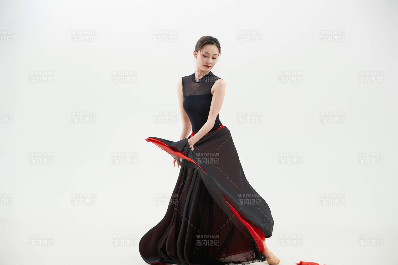 身穿红黑相间的舞蹈长裙翩翩起舞的少女图片