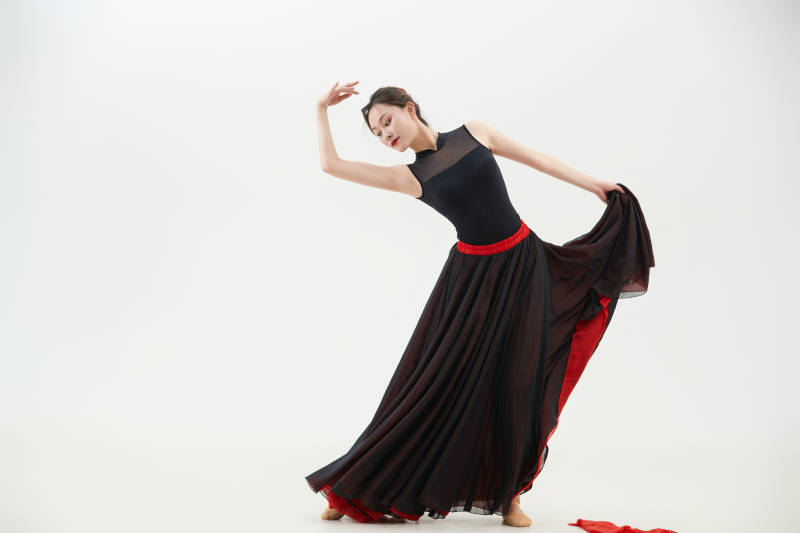 身穿红黑相间的舞蹈长裙翩翩起舞的少女图片