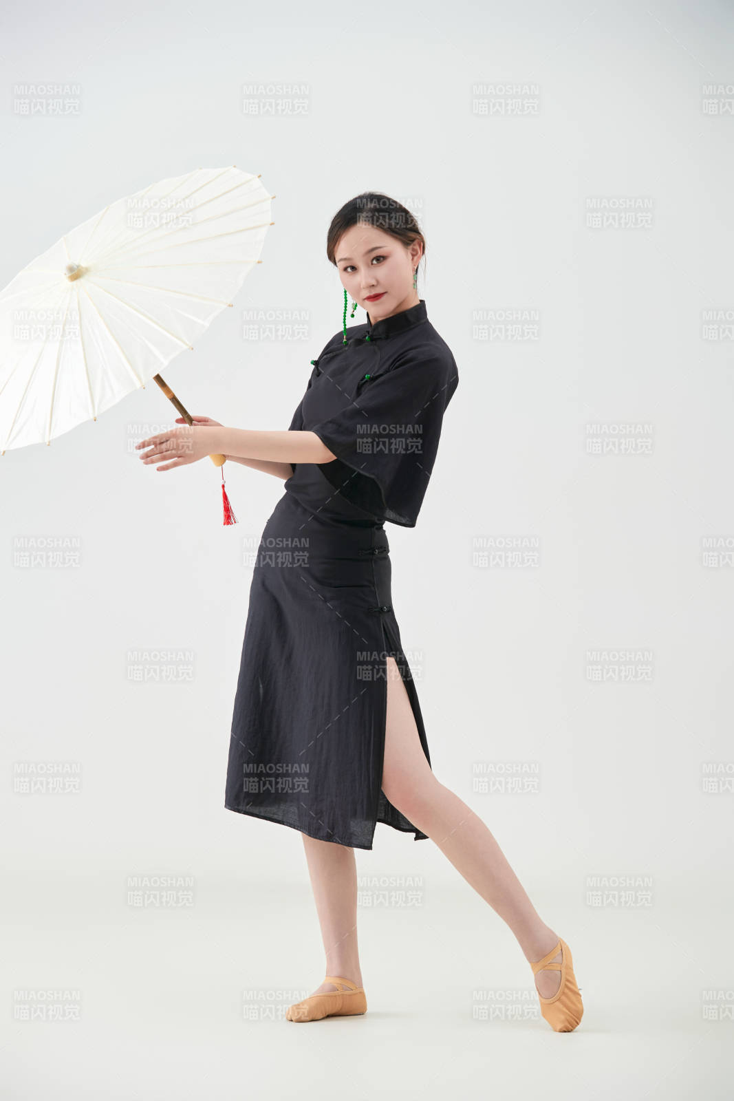 穿中式旗袍手拿油纸伞翩翩舞蹈的亚洲少女舞者图片