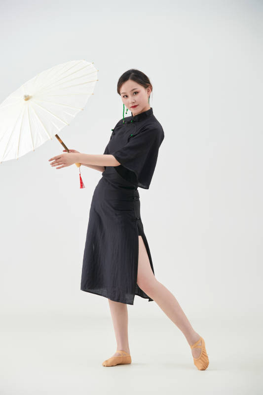 穿中式旗袍手拿油纸伞翩翩舞蹈的亚洲少女舞者图片