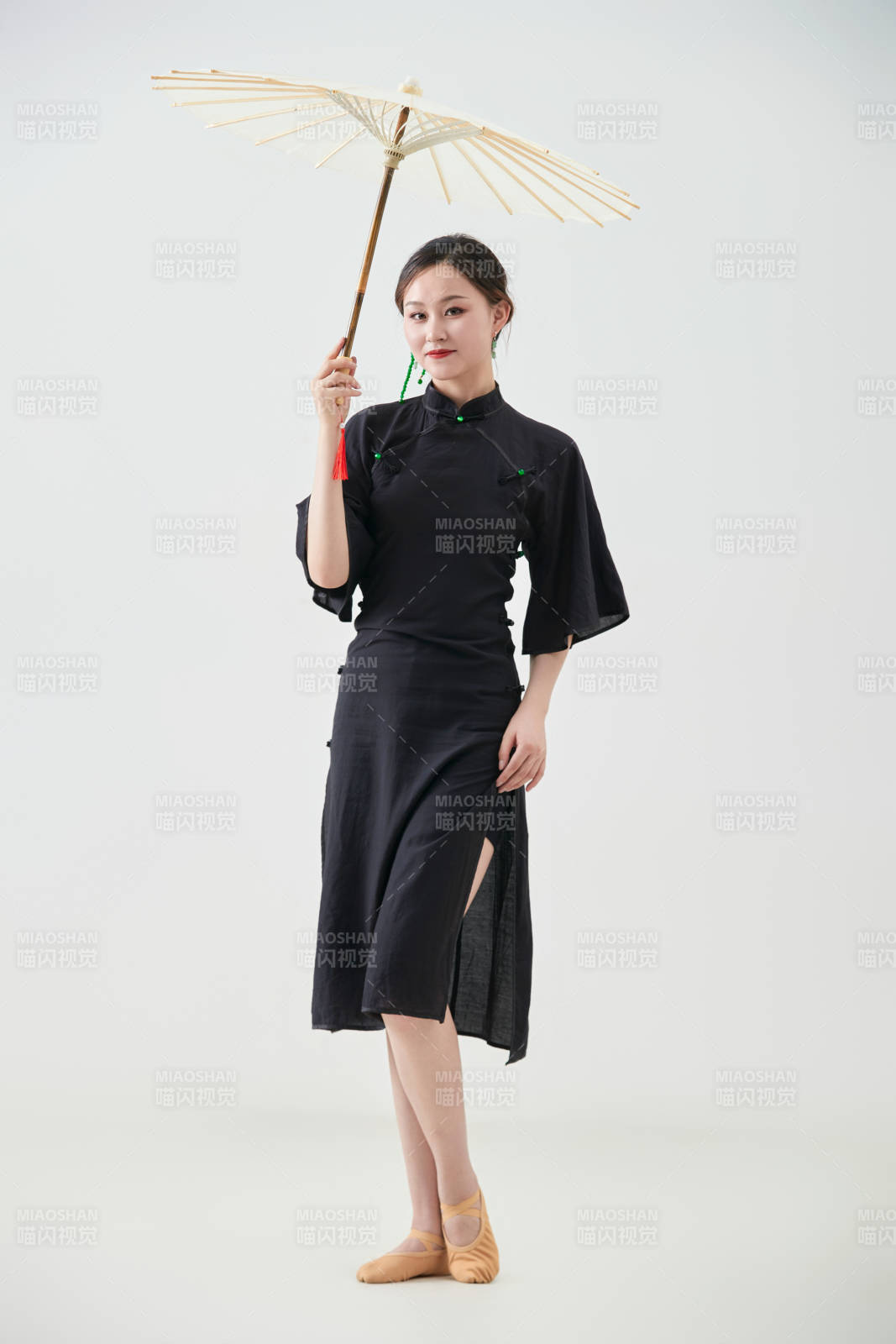 穿中式旗袍手拿油纸伞翩翩舞蹈的亚洲少女舞者图片