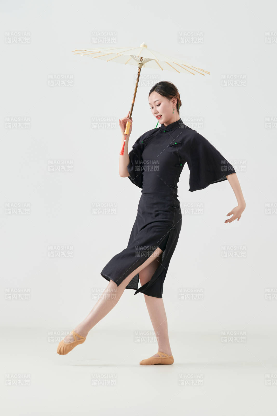 穿中式旗袍手拿油纸伞翩翩舞蹈的亚洲少女舞者图片