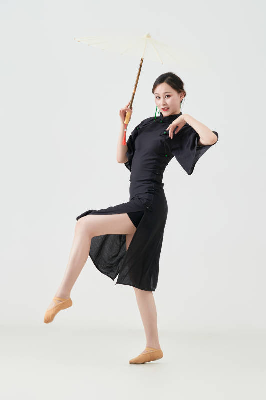 穿中式旗袍手拿油纸伞翩翩舞蹈的亚洲少女舞者图片