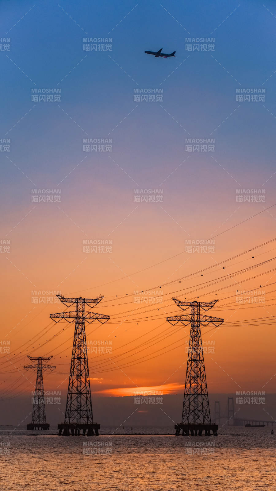 夕阳下的电力塔与飞机图片