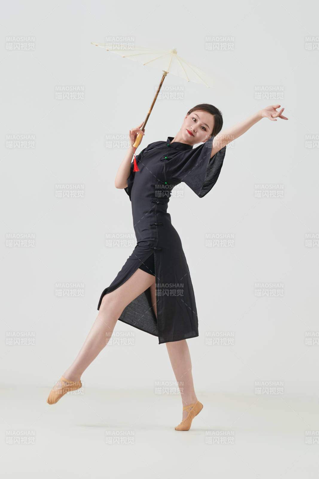 穿中式旗袍手拿油纸伞翩翩舞蹈的亚洲少女舞者图片