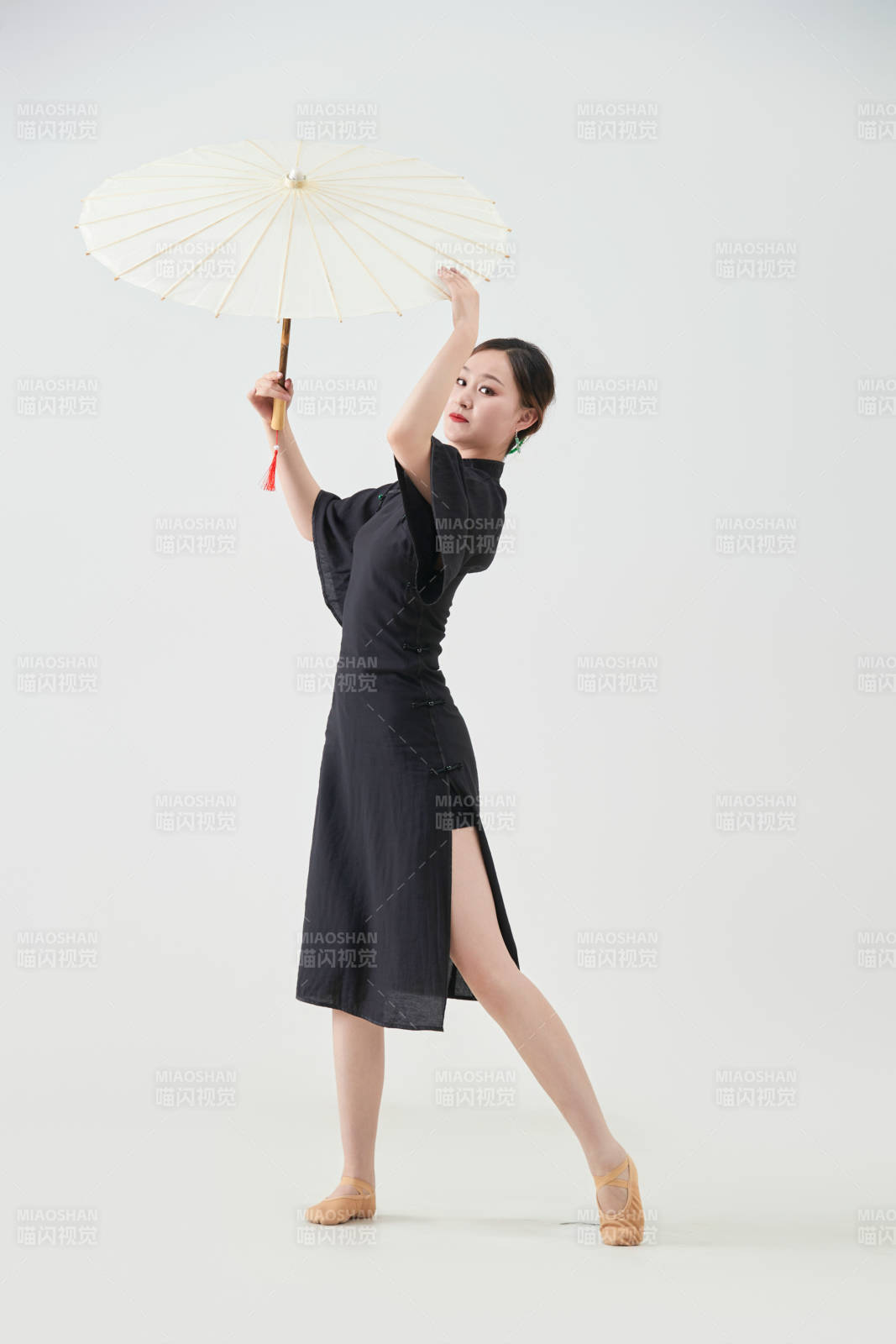 穿中式旗袍手拿油纸伞翩翩舞蹈的亚洲少女舞者图片