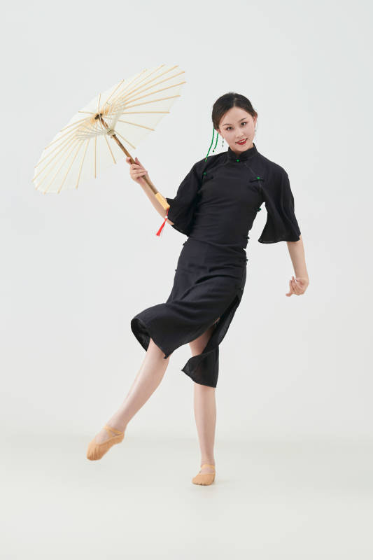 穿中式旗袍手拿油纸伞翩翩舞蹈的亚洲少女舞者图片